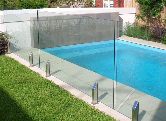 A beautiful clean glass pool fence totally compliments the lovely clear blue water of the swimming pool in this yard
